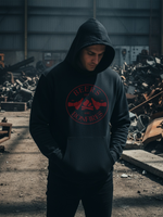 Load image into Gallery viewer, Person wearing a black hoodie with red logo in an industrial setting
