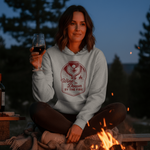 Load image into Gallery viewer, Woman in a hoodie with a fire and wine theme, holding a glass of wine by a campfire.
